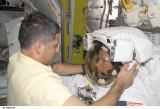 Lopez-Alegria přijímá pomoc od Lockharta při přípravě na EVA-1 (26.11.2002)