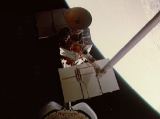 Porouchaná družice SMM po zachycení manipulátorem RMS (10.04.1984)