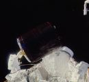 Allen drží družici Palapa po zachycení při EVA-1 (12.11.1984)